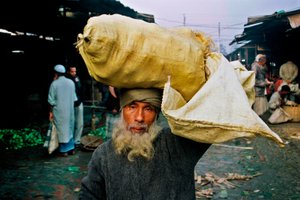 Portret van een groenteverkoper. Abdus Samad koopt groenten op de groothandelsmarkt en verkoopt ze op straat. Nirala kacha bazar, Khulna, Bangladesh.